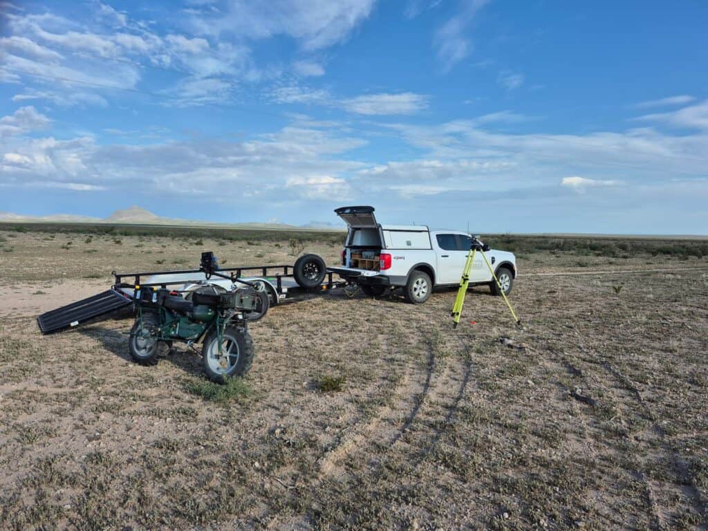 High-precision land surveying equipment setup in a vast desert landscape.